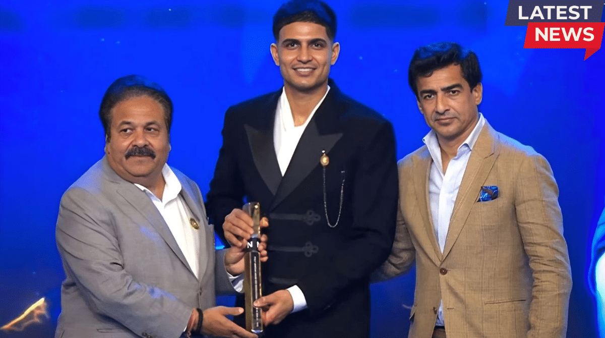 Shubman Gill receiving the International Cricketer of the Year award at the BCCI NAMAN Awards ceremony, standing with officials on stage under blue lighting.