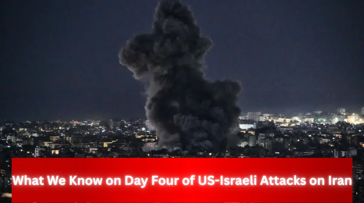 Large plume of dark smoke rising over a city at night, with headline text reading “What We Know on Day Four of US-Israeli Attacks on Iran.”